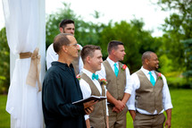 groomsmen standing next to the minister 