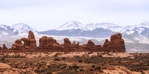 red rock formations and distant snow capped mountains 
