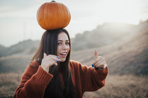 a woman with a pumpkin on her head 