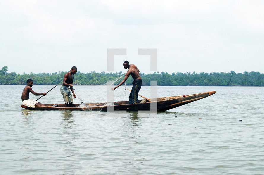 Three Nigerian's fishing on a small boat with a net