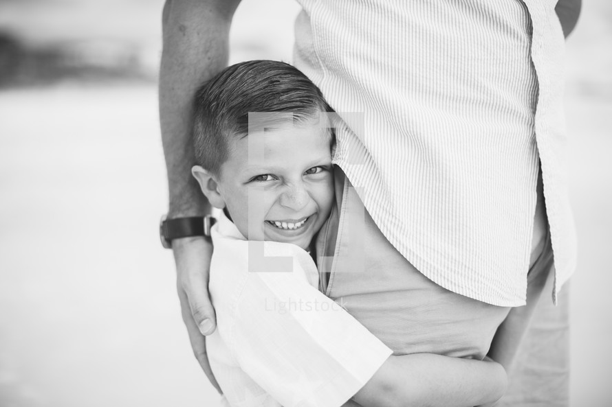 son hugging his dad's leg