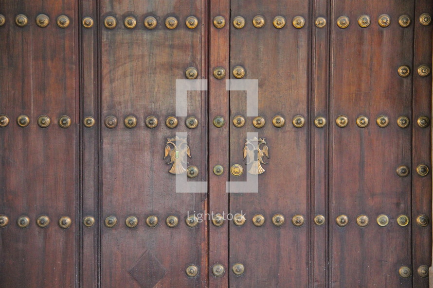 wood door with gold decorative button detail 