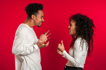 african american match emotionally quarreling on red background in studio. Concept of conflict, problems in relationships.