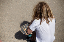 a man squatting holding a skateboard 