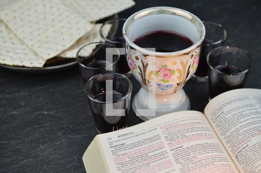 open Bible, unleavened bread, and wine cups 