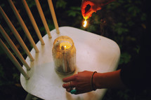 a woman lighting a candle in a chair with a match 