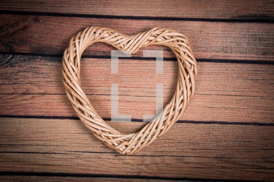 A heart shaped wreath on a wooden table.