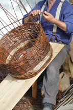 a man weaving a basket 
