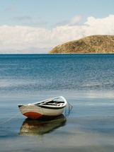 A boat floats on a calm blue sea.