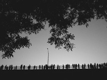 silhouettes of people on a bridge 