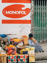 woman selling fruit on a street corner 