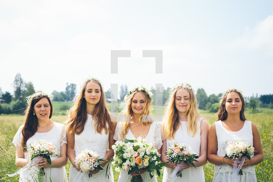 bride and bridesmaids standing outdoors 