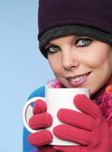 A woman in winter clothes holding a coffee cup.