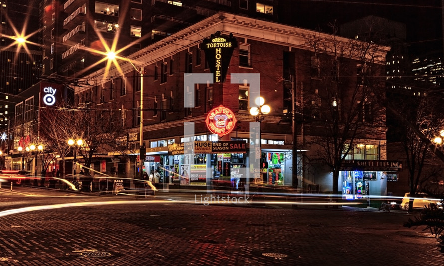 shops on a street corner at night 