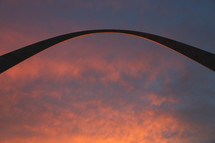 pink clouds over an arch