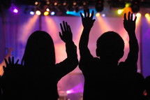 People in worship service with raised hands