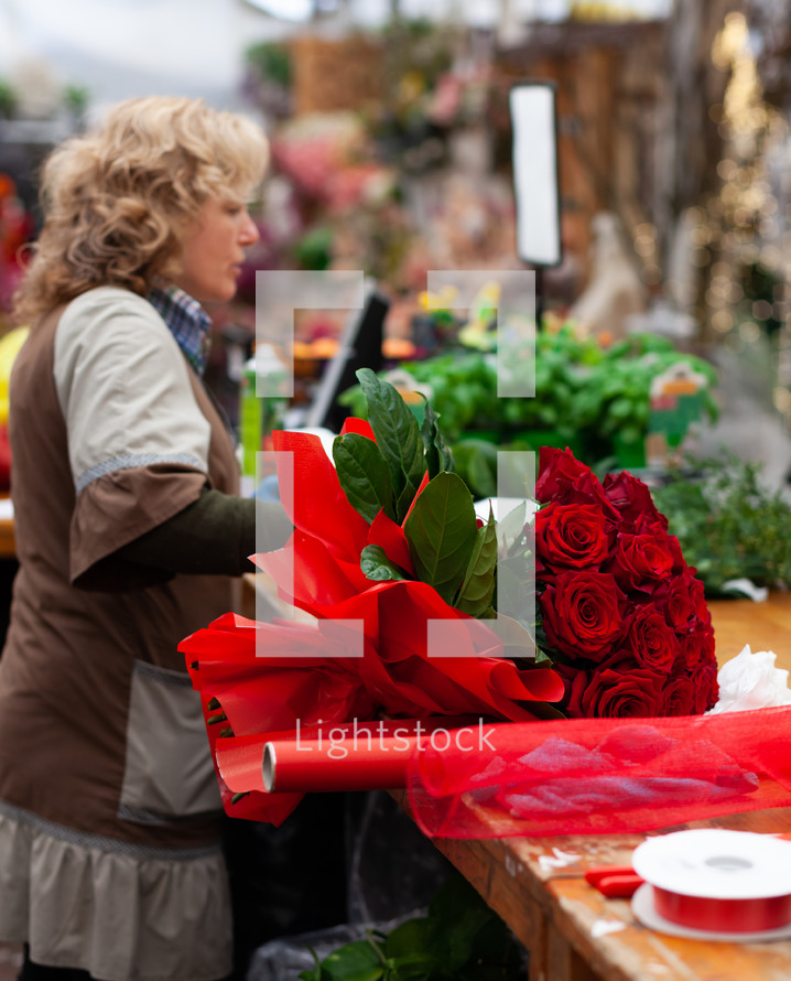 Florist with professional clothing in a nursery. Concept of craft work with flowers.