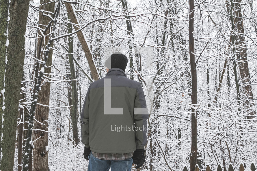 man standing outdoors in a forest in winter 