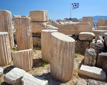 Ancient ruins in Athens with Greece flag on background