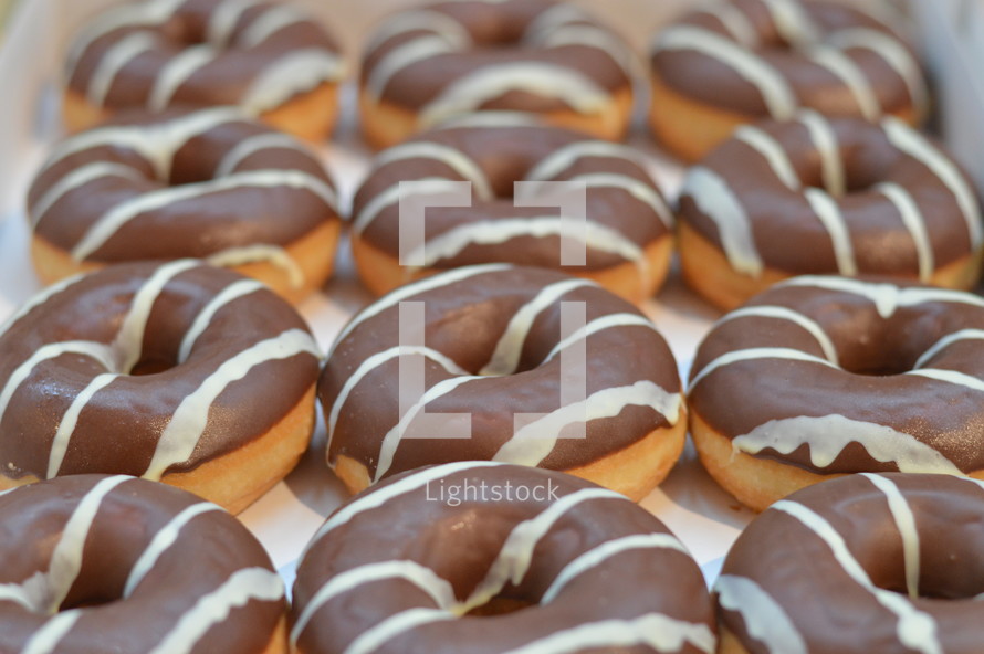 A tray of chocolate covered donuts.