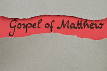 Gospel of Matthew - torn open kraft paper over light red paper with the name of the Gospel of Matthew