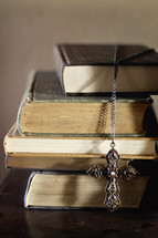criss necklace on a stack of books 