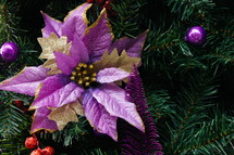 purple poinsettia ornament on a Christmas tree