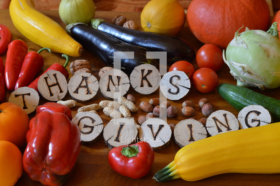 fruits and vegetables with burned wood showing the word thanksgiving. 