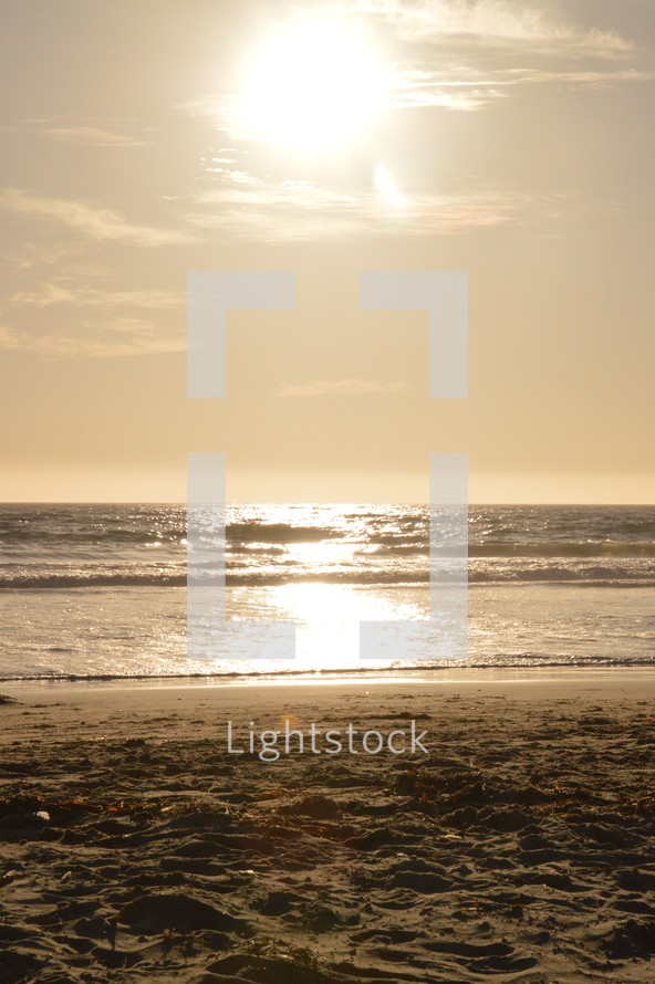 Bright sunlight shining on the ocean by the beach.