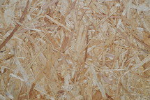 oriented strand board. 
oriented strand board, OSB, wood, background, texture, panel, plank, rough, raw, bleak, grain, vein, wall, abstract, notional, conceptional, boarding, board, wooden, timber, lumber, framing, structural, structural work, woodfiber, woodfibers, woodfibre, wood fiber, fiber, fibrous, brown
