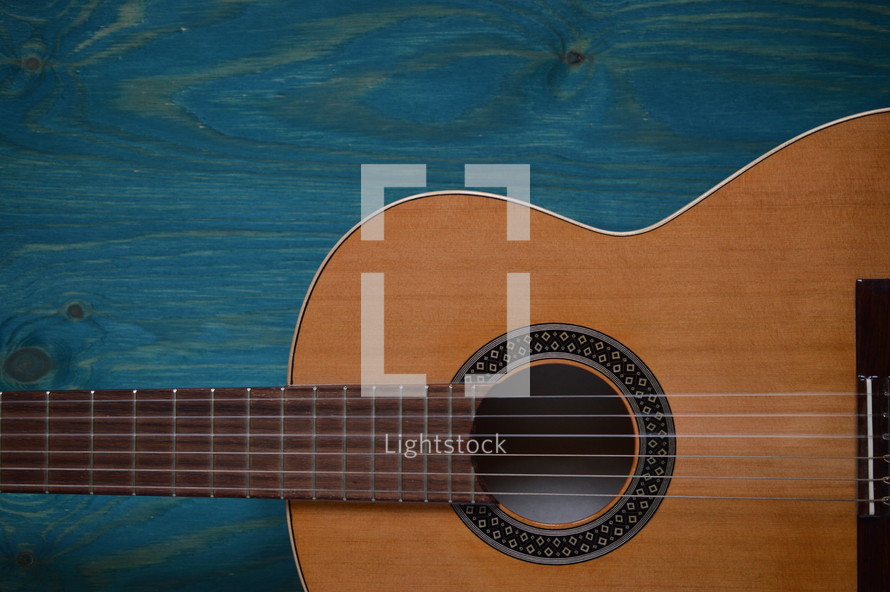 acoustic guitar on teal wooden background