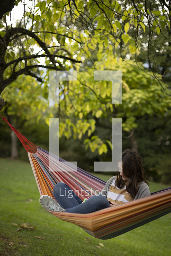 Woman in a hammock reading 