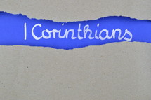 Title 1 Corinthians exposed under gray torn paper 