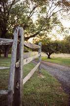 rustic wood fence along a gravel road 