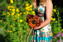 Girl carrying sunflowers.