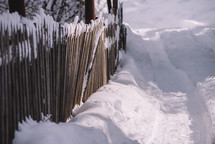 Old wooden fence in a snowy village