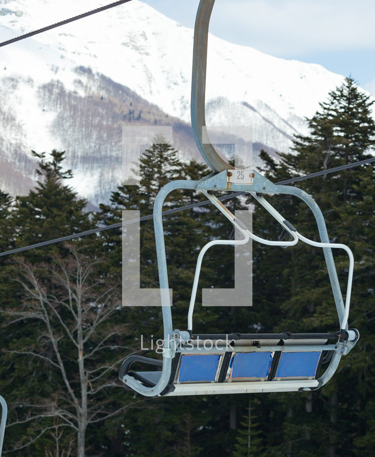 Chair lift on over the snowy forest at Abetone, Italy.