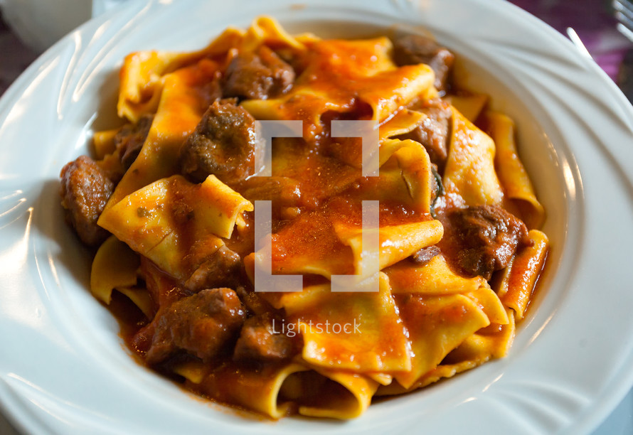 Pappardelle with boar ragu. Tuscan typical recipe of italian pasta.