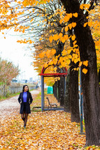 A young woman in a park surrounded by fall colors 