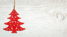 red Christmas tree ornament on a white wood background 