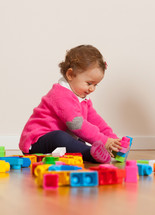 baby girl playing with toy blocks 