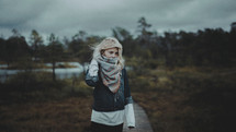 a woman covering her face with a scarf outdoors 