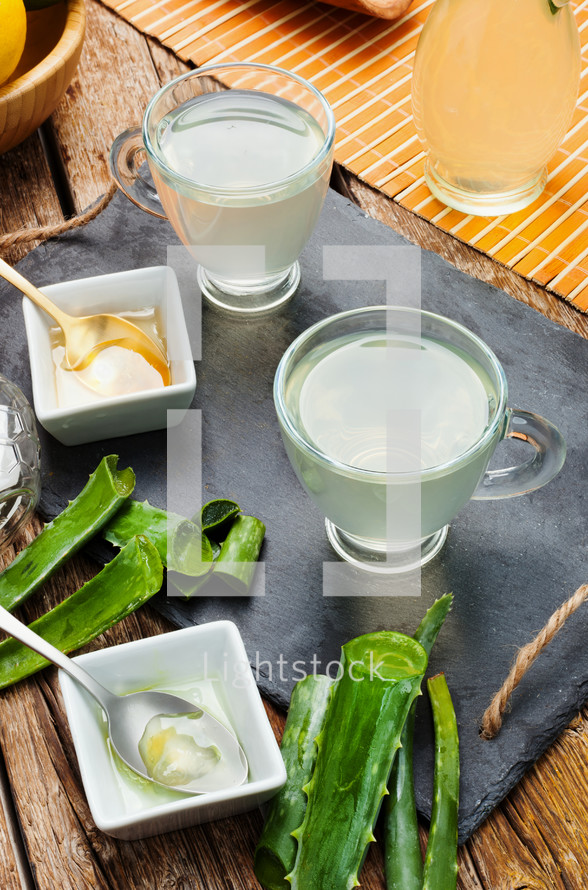 Drink aloe vera and honey. Glass cups on a slate tray.