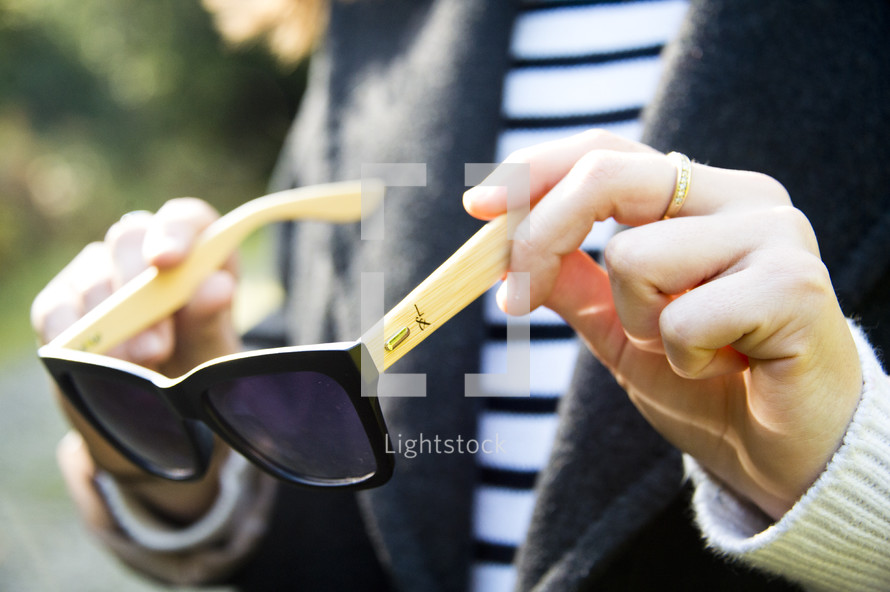 a woman holding sunglasses 