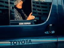 woman with her hand out a bus window 
