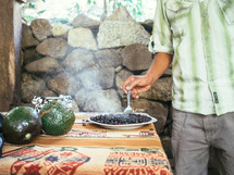 Man stirs a steaming bowl of black beans.