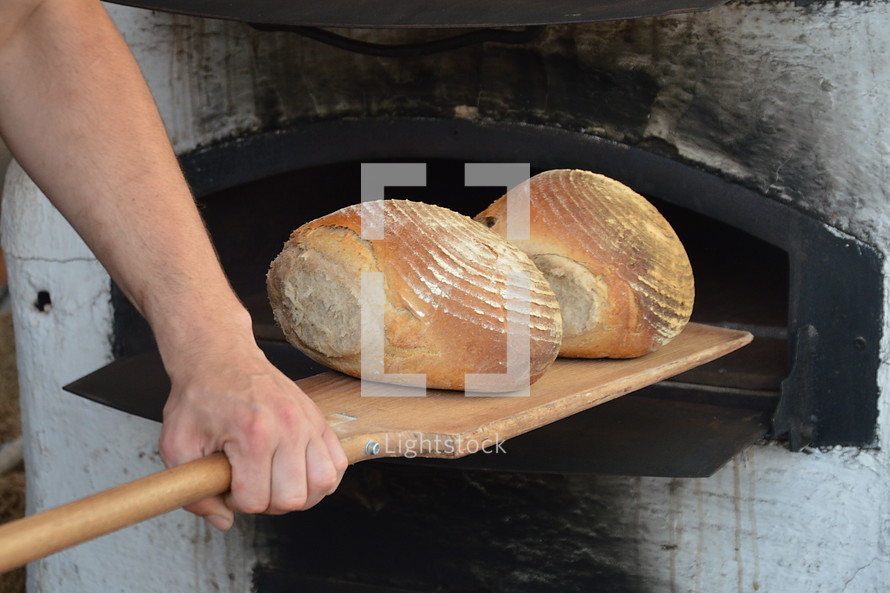 Removing freshly baked bread from a stone oven.