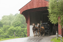 horse and carriage through a covered bridge 