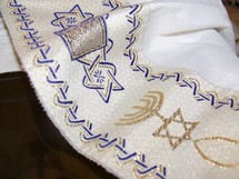 The Tallit, A Jewish Prayer Shawl that covers the head of Jewish people as they pray.