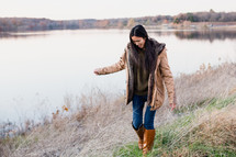 young woman walking outdoors in coat and boots